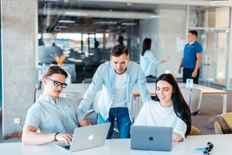 IT team collaborating on laptops for co-managed IT services